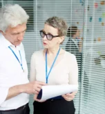 Healthcare professionals discussing documents in an office, highlighting the importance of understanding credentialing vs contracting in healthcare.